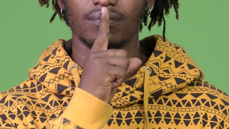 young handsome african man with finger on lips