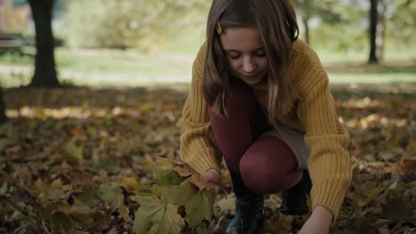 caucasian girl picking leaves in the woods.