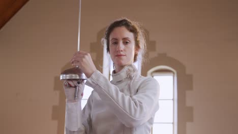 Female-fencer-athlete-during-a-fencing-training-in-a-gym