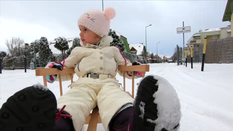 Una-Niña-Está-En-Un-Trineo-De-Nieve