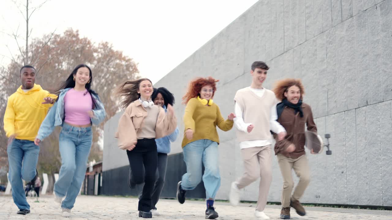 Low angle view of diverse friends laughing and running outdoors