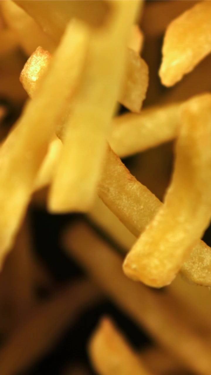 Macro Shot of Crispy Golden French Fries Coming into Focus