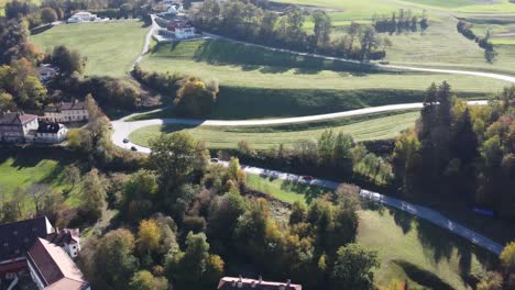 Aerial-view-of-cars-rushing-along-a-track-full-of-tranquility-in-the-alpine-green-valley-near-the-city-of-Innsbruck-on-a-sunny-autumn-day-in-Tyrol-in-Austria