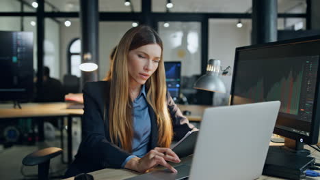 Office-worker-checking-papers-in-lamp-light.-Woman-employee-working-computer