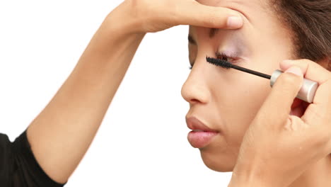artista de maquillaje poniendo máscara en la cara de las modelos