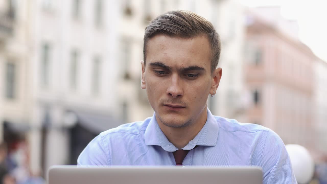 Man working on laptop in urban setting