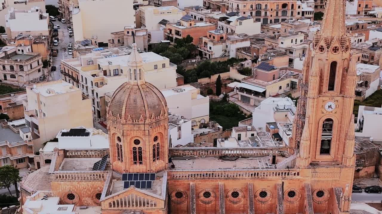 Vista di una chiesa e di una città a Malta durante il tramonto