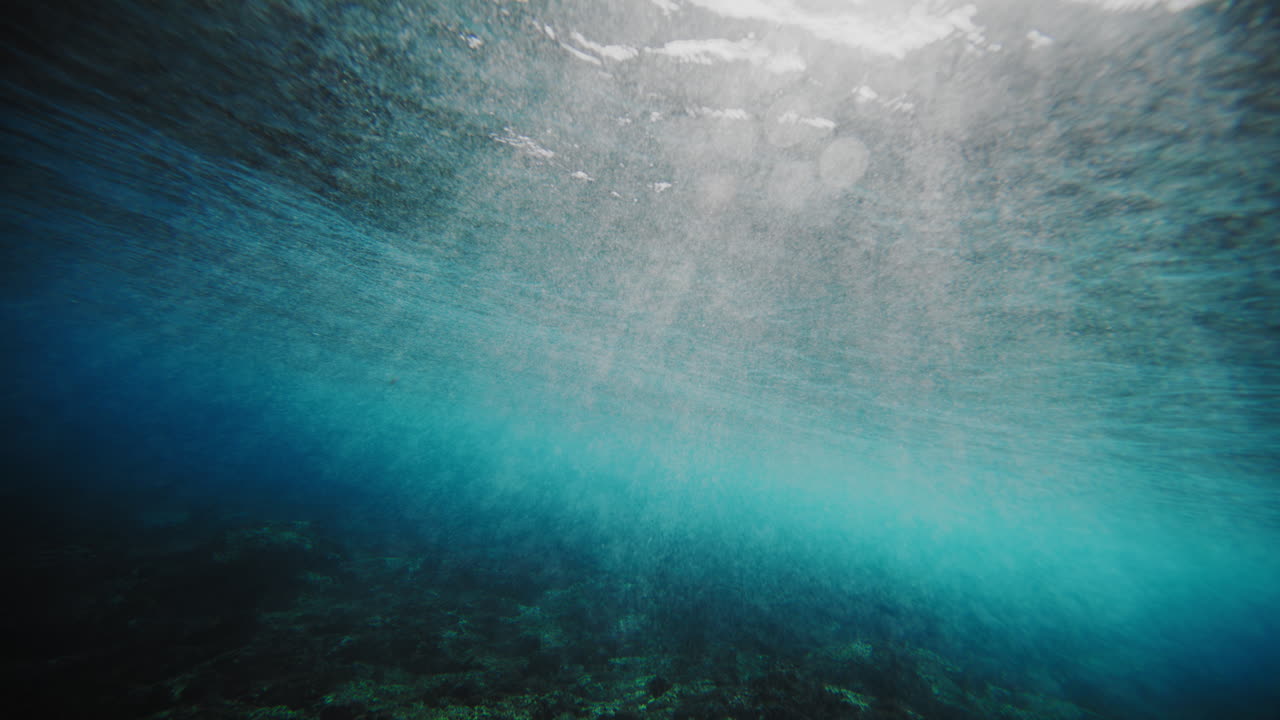 vista submarina del océano en cloudbreak fiji mientras la luz del sol brilla detrás del barril