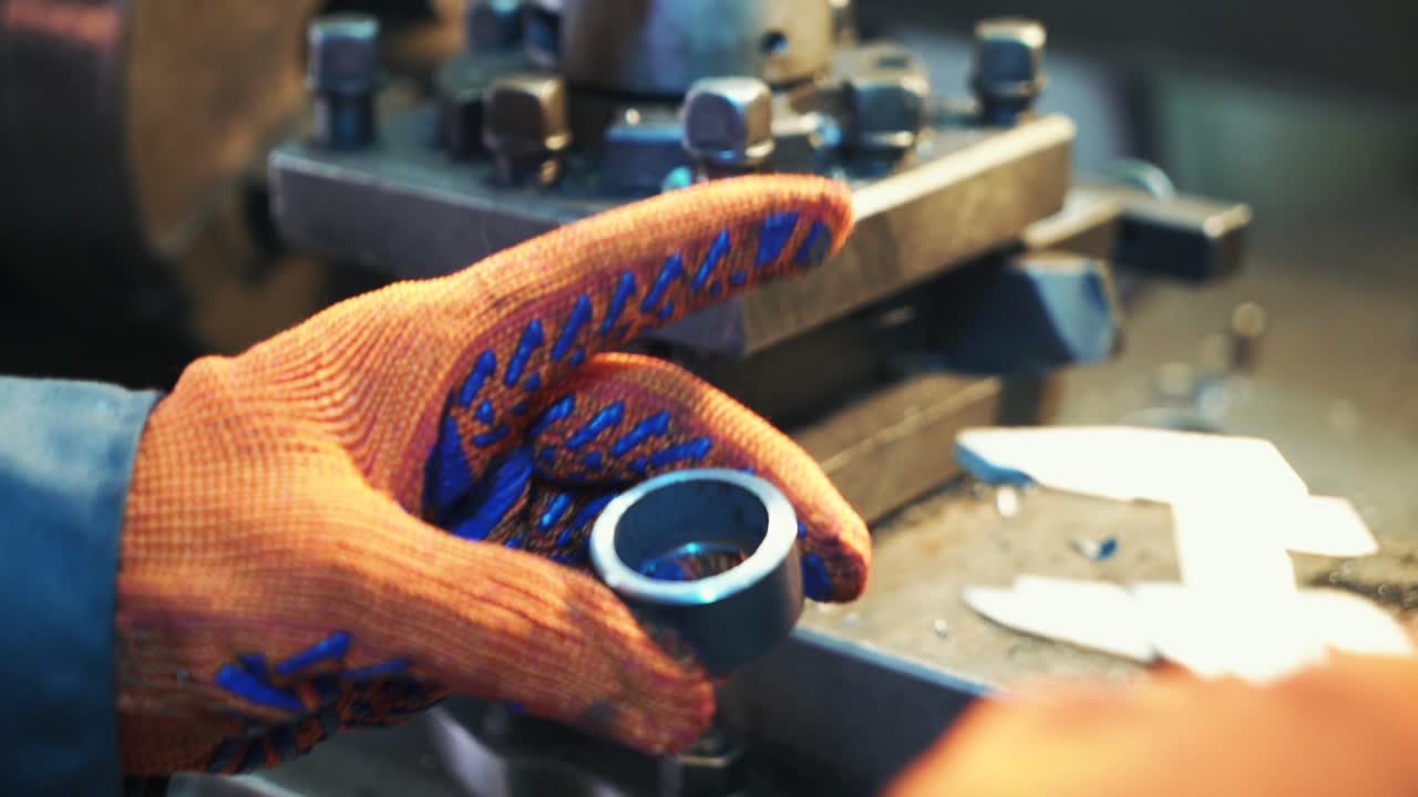 Un operaio industriale sta lavorando a un processo di fabbrica di lavorazione dei metalli, eseguendo un'operazione di tornitura meccanica su una macchina per l'industria delle strutture in acciaio. Mani in primo piano.