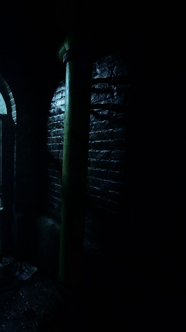 Light shines through an archway in a dark and empty hallway