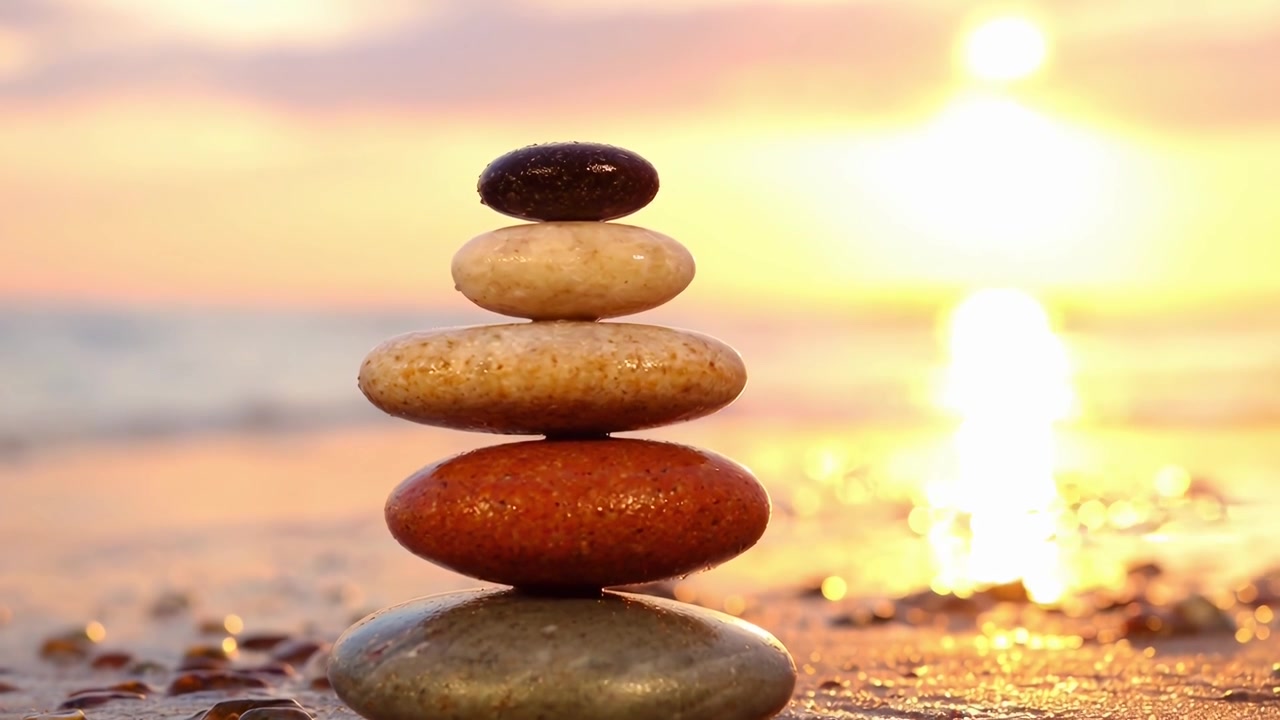 Peaceful Stone Cairn on Beach with Golden Sunset Reflection
