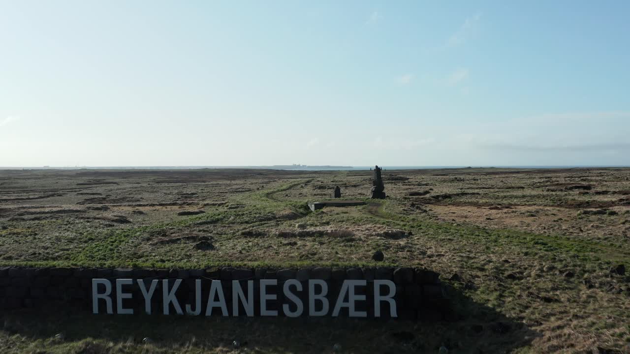 Reykjanesbær-skilt med hvide bogstaver på en bakke på Island, luftfoto.