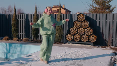 woman dancing in winter garden near pool