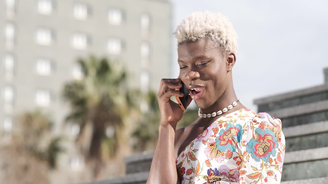 Transgender person talking on mobile phone outdoors.