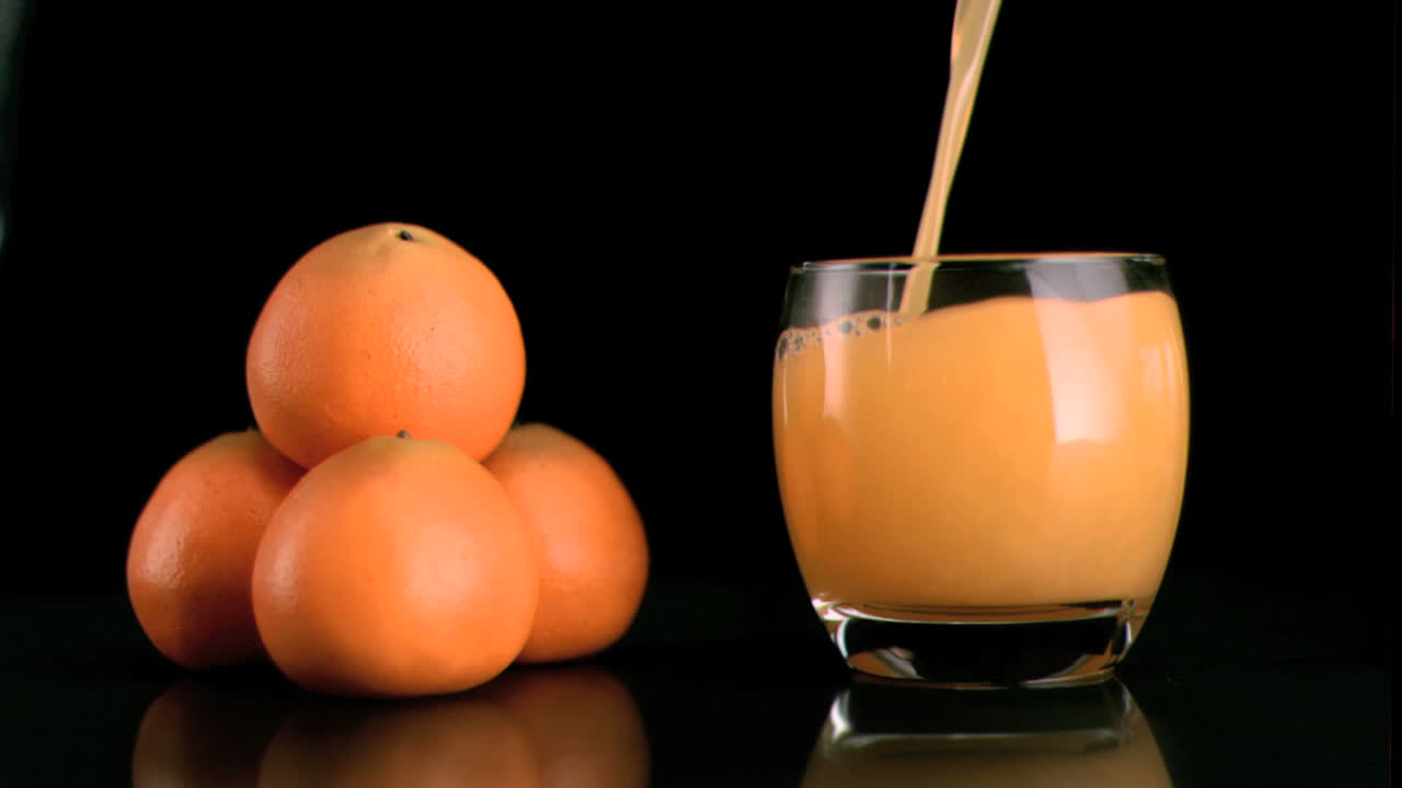 Succo di mandarino versato in un bicchiere in super slow motion
