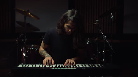 hombre tocando el teclado en un estudio de música
