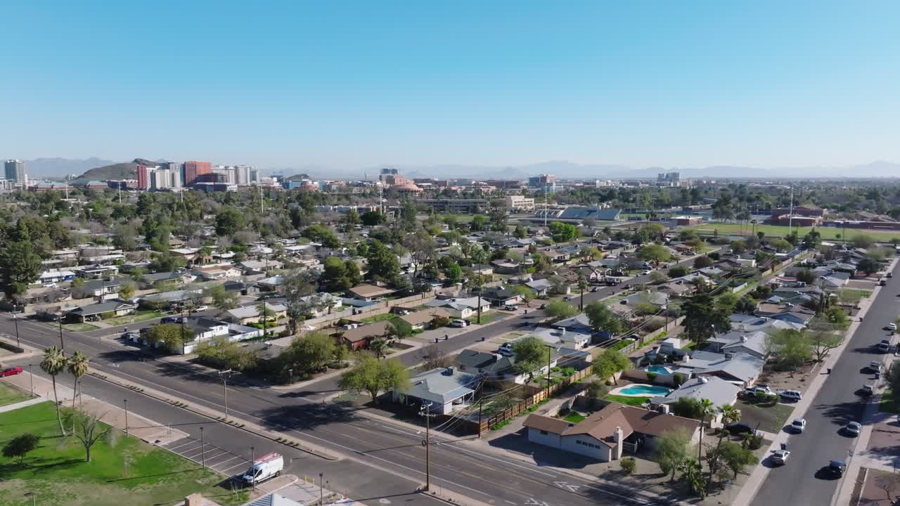 아리조나 주 템페의 중산층 주거 지역, 멀리 있는 고층 빌딩이 있는 시내, 고귀한 집과 수영장이 있는 교외의 빛 날, 공중 포워드 와이드.
