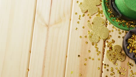 video of st patrick's green hat, shamrock and bow tie on wooden background