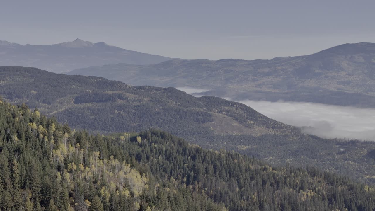 elevada elegancia: imágenes aéreas de valles envueltos en nubes y picos de colores de otoño