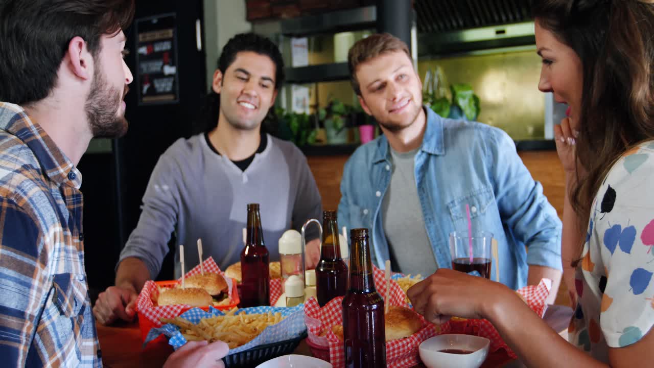 amigos comiendo hamburguesas en un restaurante