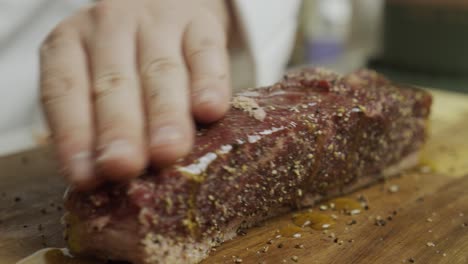 adding olive oil onto meat steak on the cutting board