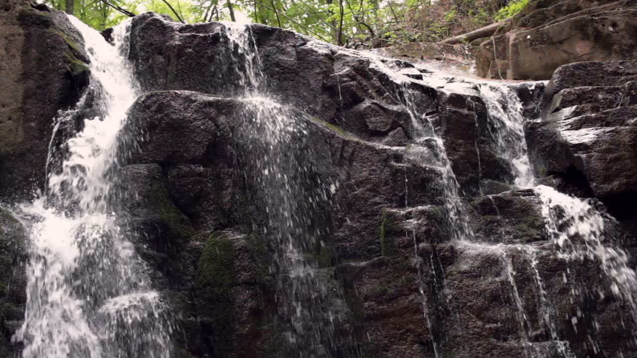 agua que fluye en un camino rocoso en un parque natural. arroyo de cascada de montaña