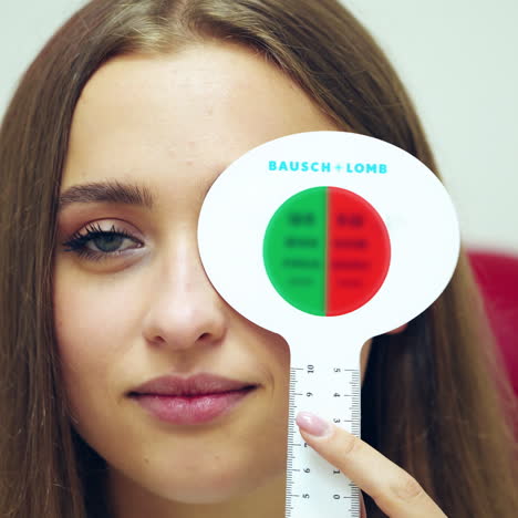 portrait of a woman with occluder. beautiful female checking her eyes at ophthalmologist. girl with one eye closed speaks during vision check up.