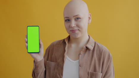 mujer sosteniendo un teléfono con una pantalla verde
