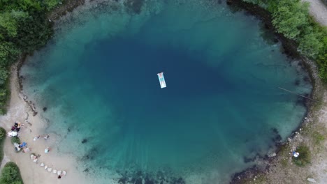 Persona-Adulta-Tumbada-Sobre-Una-Alfombra-De-Agua-Flotante-En-El-Manantial-De-Izvor-Cetina,-Aérea