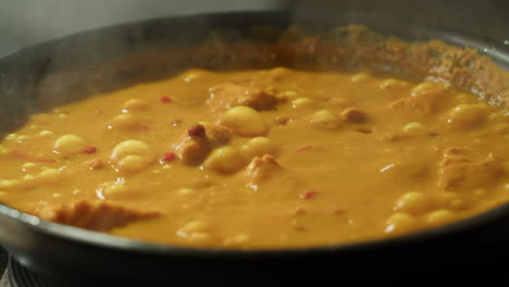 yellow boiling sauce on pan close-up. asian cuisine concept. curry is a dish with a sauce seasoned with spices. curries may contain fish, meat, poultry, or shellfish, either alone or in combination with vegetables. others are vegetarian.