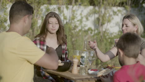 father giving roasted bread to his wife and children outdoors