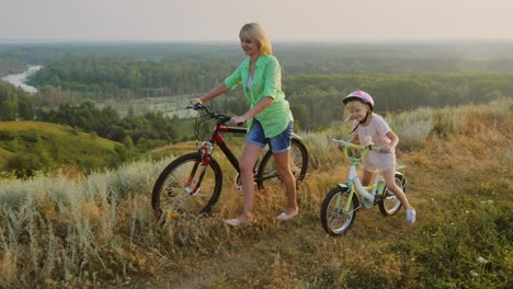 A-woman-with-a-child-rides-a-bicycle-in-nature