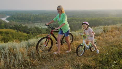 una mujer con un niño anda en bicicleta en la naturaleza