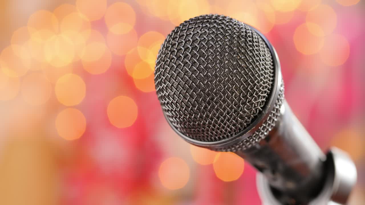 Microphone on stage against a blurry light ,blurry background.