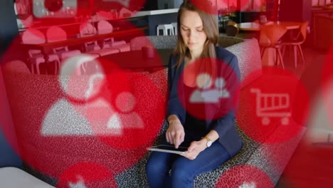 digital icons against woman using digital tablet