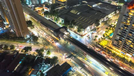 Aerial-orbit-over-a-subway-station-in-Santiago-Chile-with-a-trail-of-lights-from-cars-and-cars-of-the-transport-system-at-night