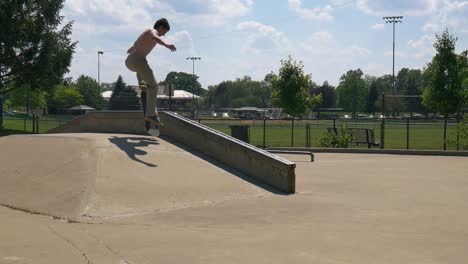 man does a smith grind on their skateboard down the rail at the skatepark