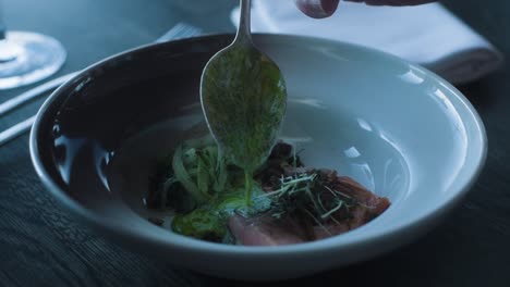 person eating fish dish in fine dining restaurant, close up