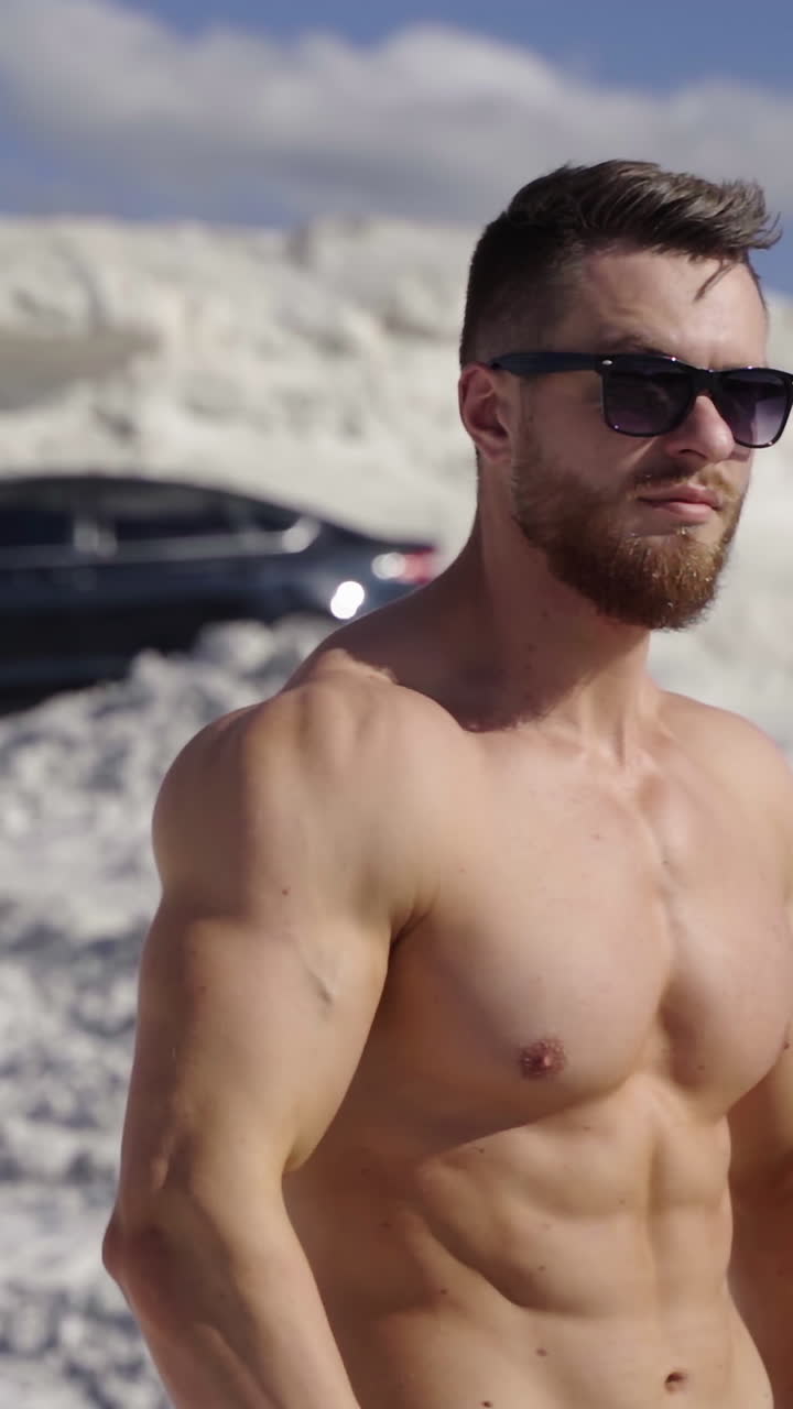 Bodybuilder posing on nature. Beautiful and muscular young shirtless man