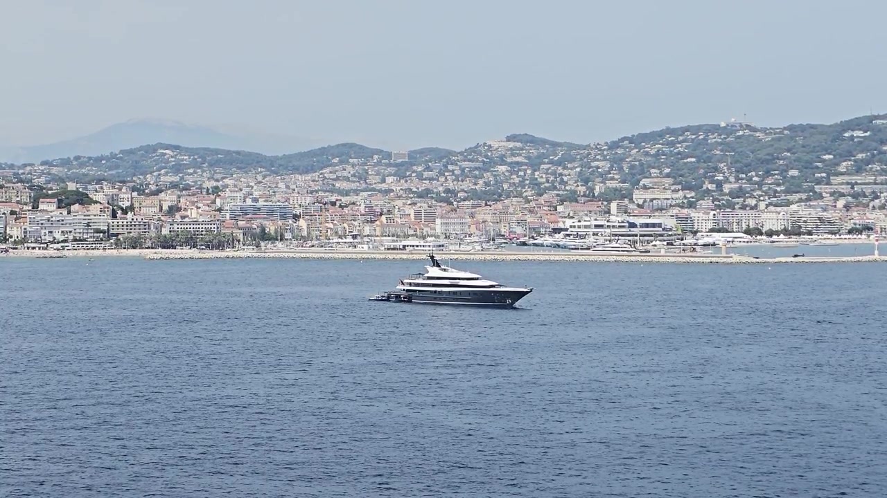 Vista statica di uno yacht di lusso che galleggia al largo di Cannes con lo sfondo della città