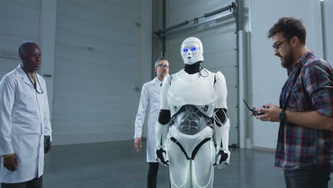 scientists and engineers observing a robot in a factory