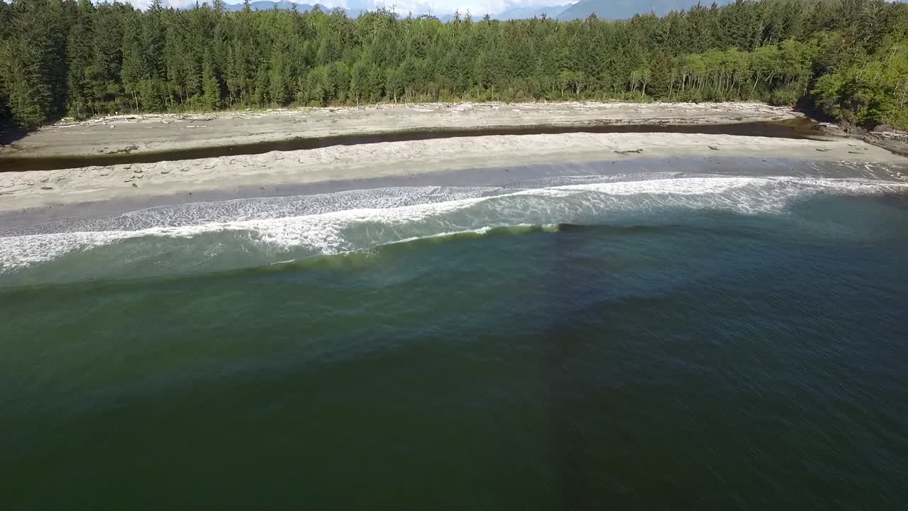 vista aérea de las olas rompiendo en la playa de arena de tofino, columbia británica en la punta de la isla de vancouver