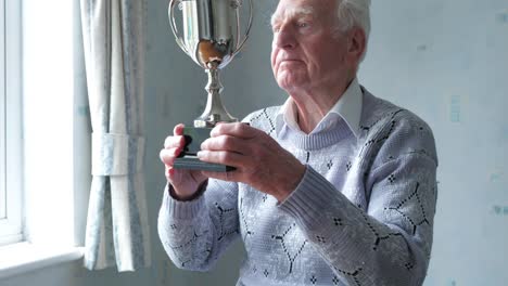 senior caucasian man cleaning his trophy