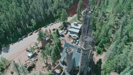 drone view of a castle like building in the middle of the forest in countryside of colorado