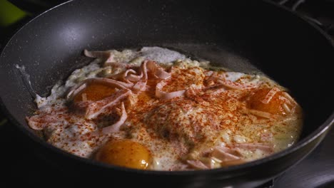 Preparing-bubbling-hot-breakfast-hand-and-egg-layered-tortilla-wrap-in-frying-pan