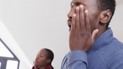 Tired-african-american-couple-talking-and-using-face-cream-in-bathroom-in-the-morning,-slow-motion