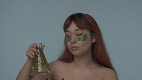 woman with eye patches and herbal flask