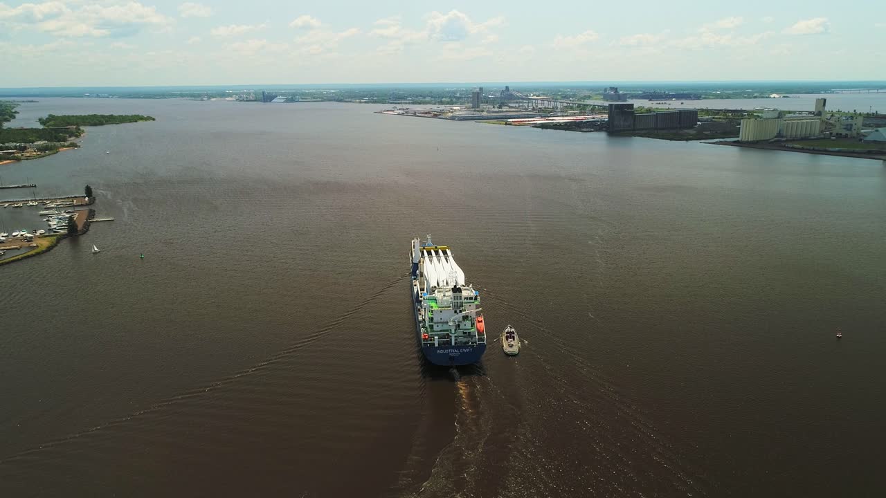 buque aéreo de carga pesada que transporta palas de turbinas eólicas en el puerto de una pequeña ciudad