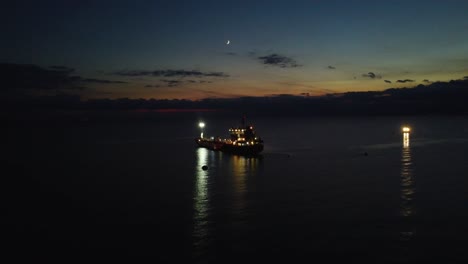 Barco-De-Aproximación-Aérea,-Petrolero-En-El-Mar-Al-Atardecer,-Vista-Nocturna