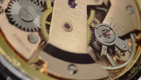 old retro wristwatch gearwheel working inside closeup macro movement